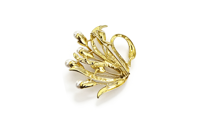 Broche in goudkleur met parelkleurige kralen, achterkant met speld