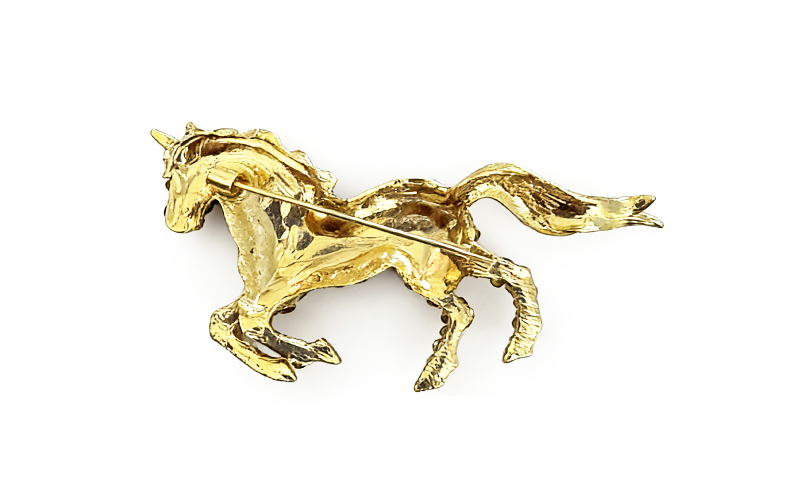 Broche in goudkleur met gele strass, achterkant met speld